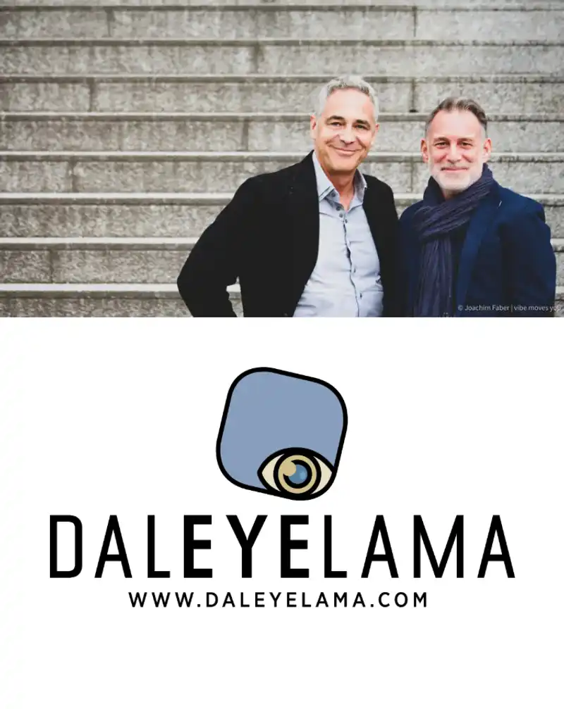 Christian Clerici und Clemens Fischer, Gründer von Daleyelama, stehen lächelnd vor einer Treppe; darunter ist das Daleyelama Logo mit Webadresse zu sehen.