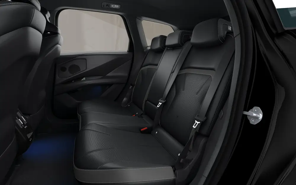 Innenraum des BMW iX3 Neue Klasse mit Blick auf die Rücksitze in dunklem Leder, moderne Türverkleidung und großzügiger Fondbereich vor transparentem Hintergrund.